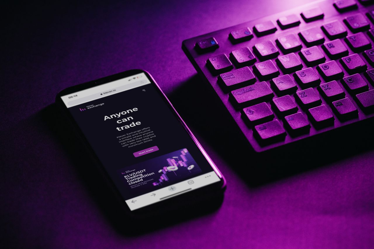 Home Close-up of a smartphone and keyboard with a purple hue, embodying modern technology and connectivity.